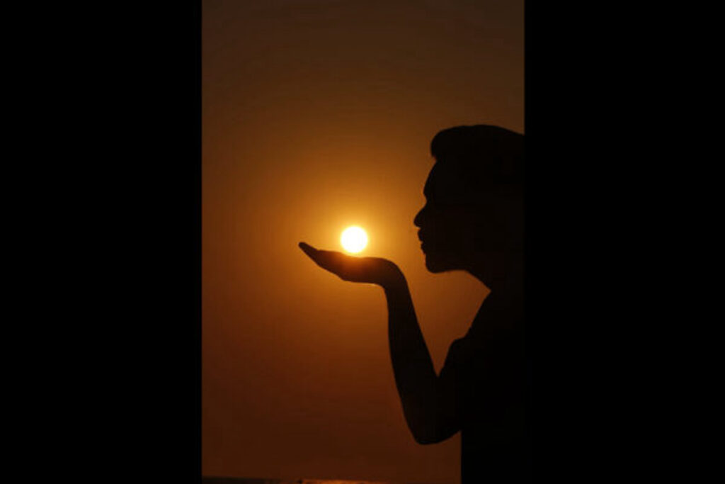 Silhouette of a person meditating at sunset symbolizing mindfulness, emotional balance, and holistic healing practices for mental wellness