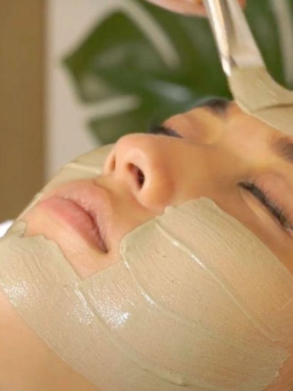 A client resting with an organic clay mask being applied