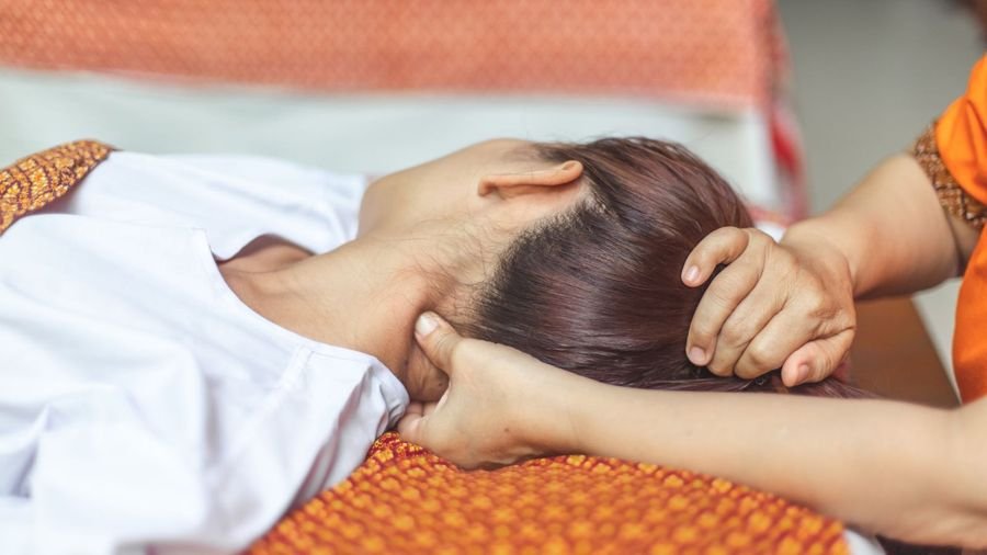 A Shiatsu session with hands supporting the client’s head